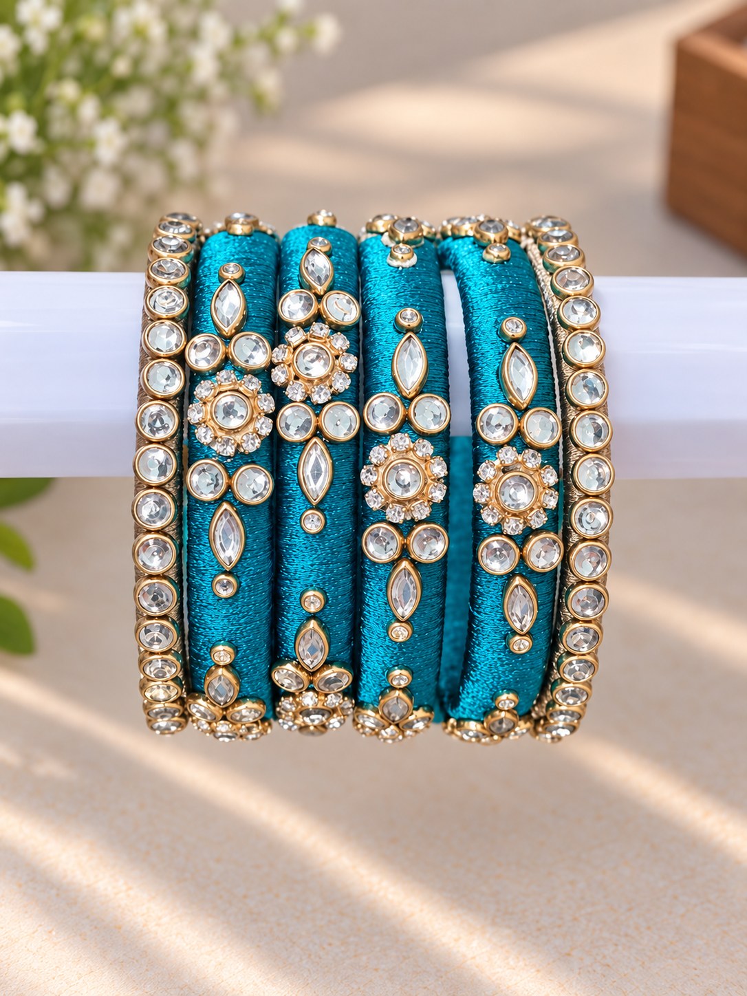 Close craftsmanship detail of teal silk bangles